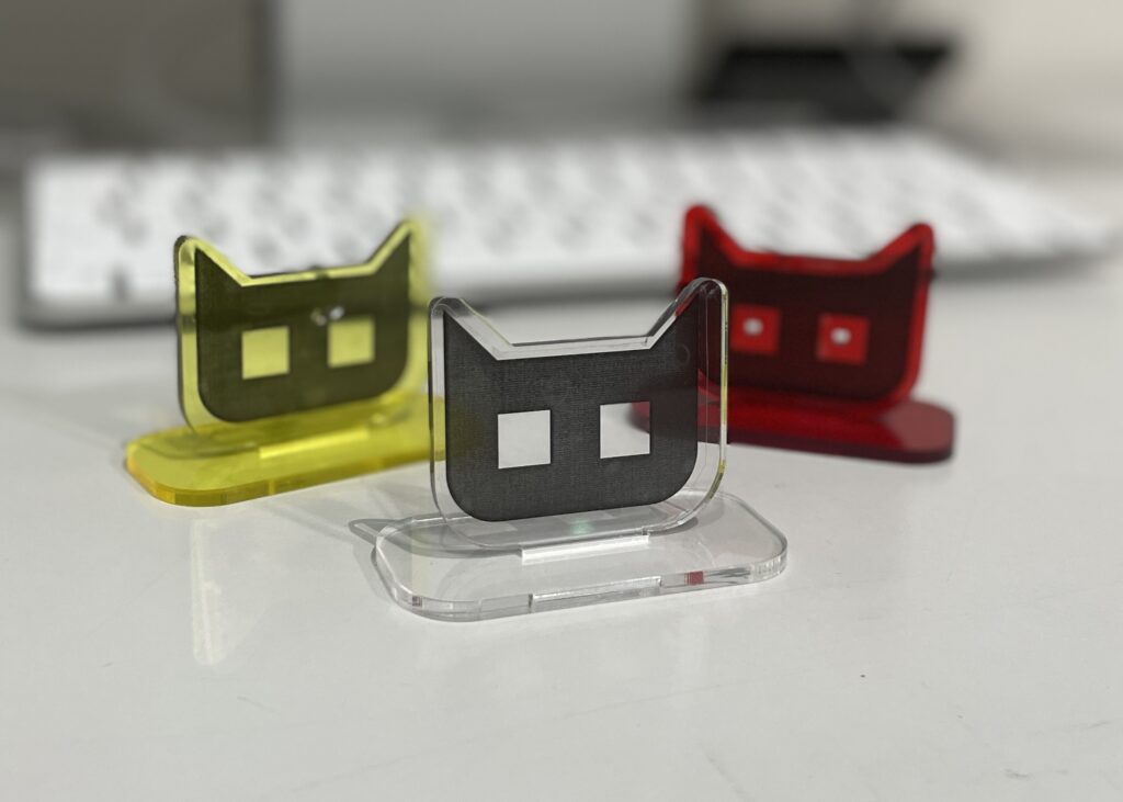 CCBTオリジナルの猫の形のアクリルスタンドの写真。赤色と黄色と透明の3種がある。