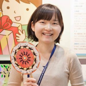 大髙那由子の顔写真。笑顔で、視覚装置のひとつ「フェナキスティスコープ」を持っている。