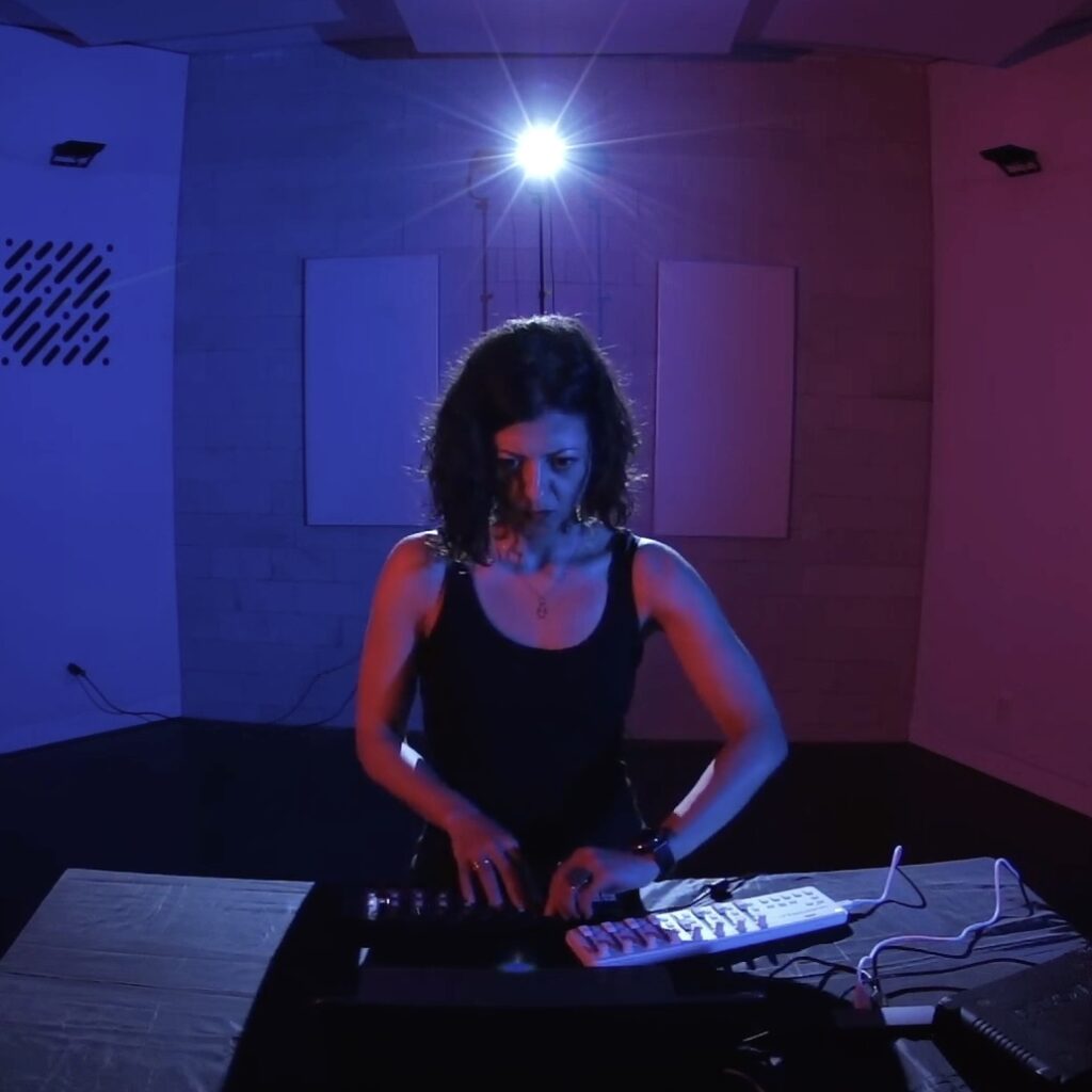 電子音楽の設備を操作している女性の写真。