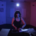 電子音楽の設備を操作している女性の写真。