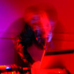 強烈なレッドライトで照らされたライブの瞬間を捉えた写真