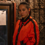 オレンジのジャケットを羽織った女性の写真